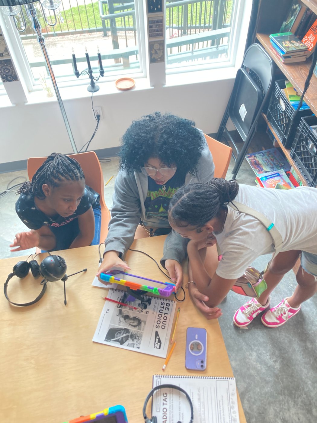 A Junior Producer helping two DJs plan a segment in their Be Loud Studios DJ journal